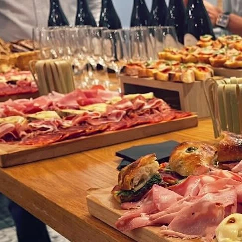 Buffet dressé chez Ham's: planches de charcuterie, sandwichs et rangée de verres à vin