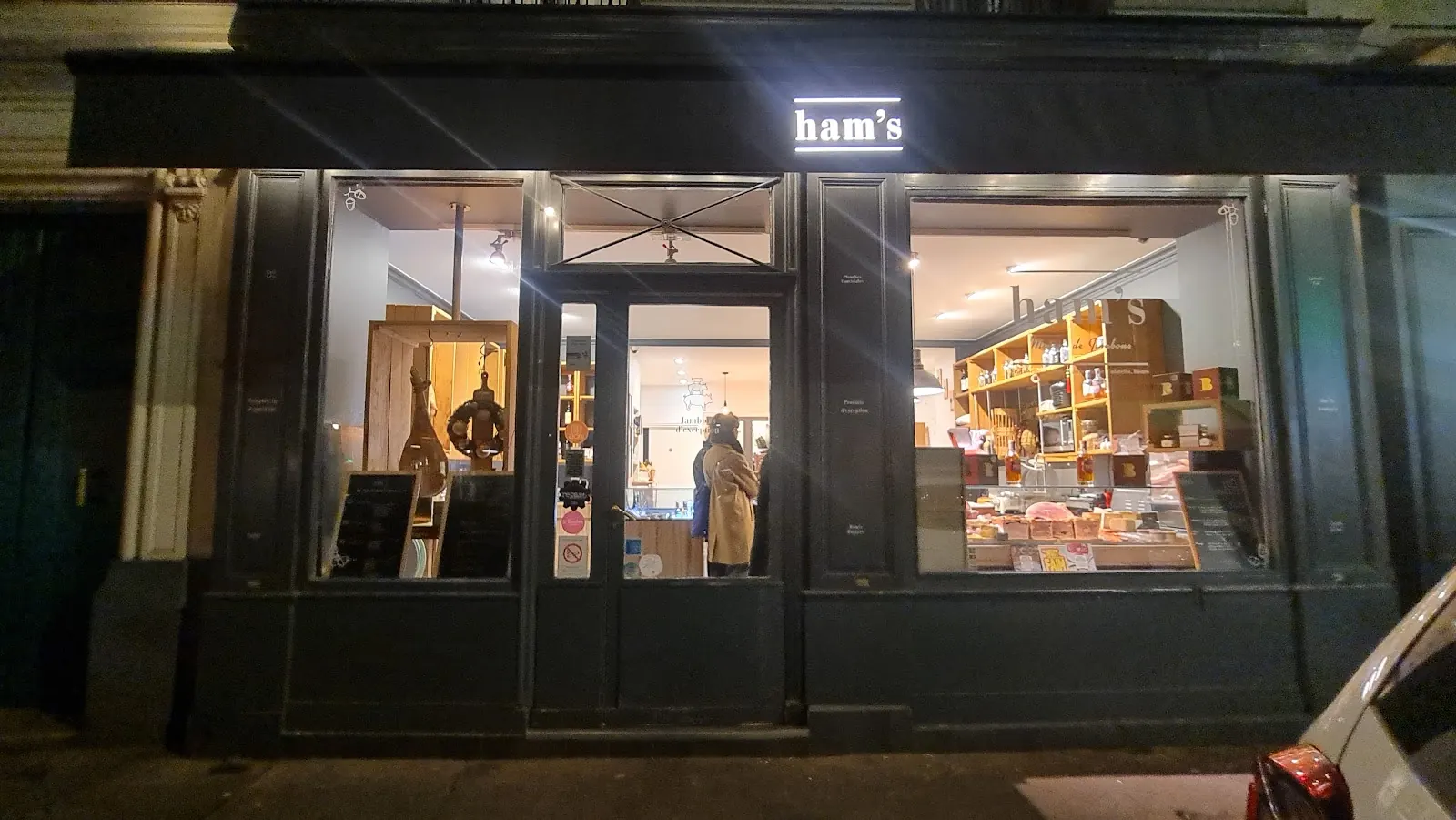 La vitrine éclairée de Ham's Maison de Jambons, 21 rue Paul Bert à Paris, le soir