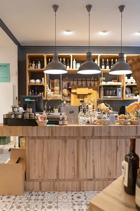 Le comptoir et la salle de dégustation de Ham's, lampes suspendues et étagères de bouteilles